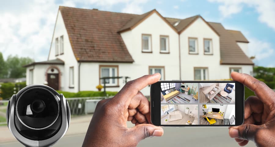 Man holding phone and looking at footage from video cameras